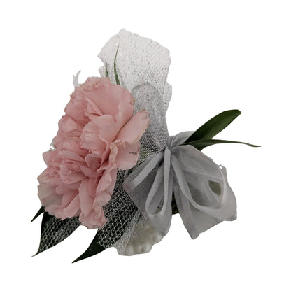 Pink carnation corsage on a pearl bracelet, side view
